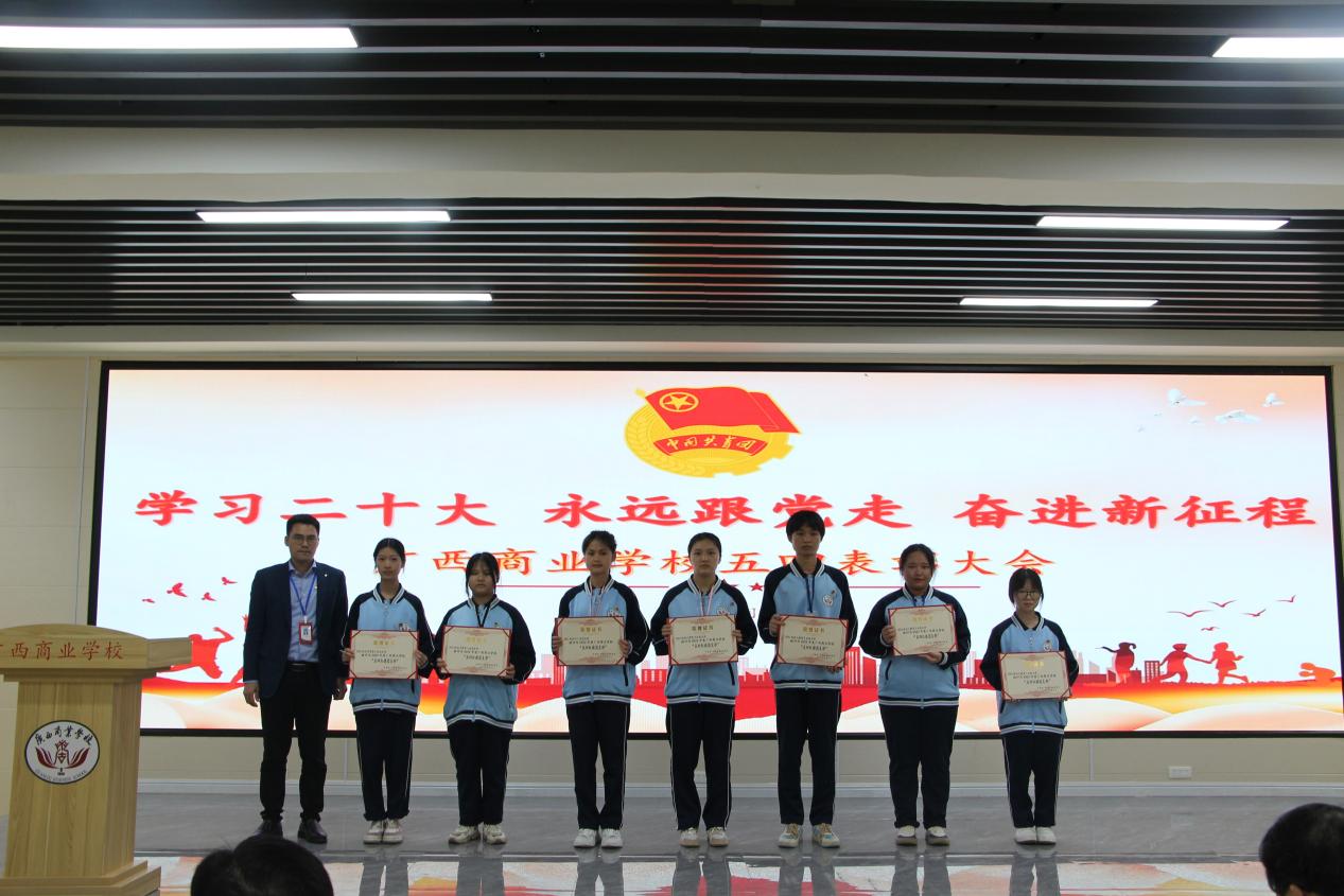 10.学校副校长吴天元(左一)为荣获“广西商业学校五四红旗团支部”荣誉称号的班级代表颁奖并合影留念
