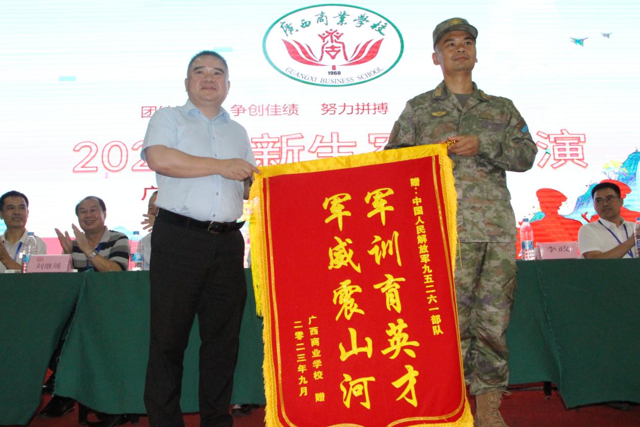 18.学校党委副书记、校长韦鹰向承训部队教官赠送“军训育英才 军威震山河”锦旗