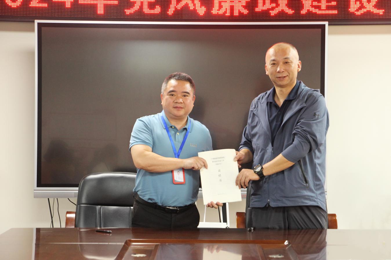 3.学校党委书记、校长韦鹰（左一）与财务科科长谢俊锋（右一）交换责任书