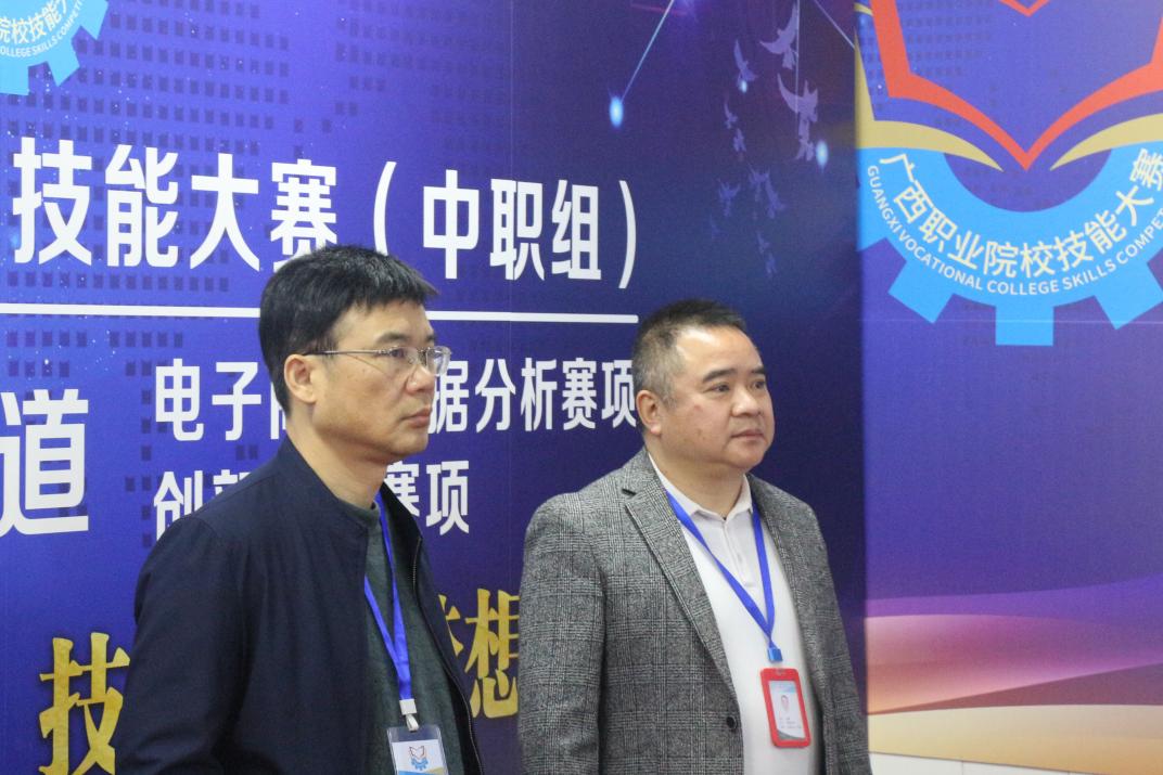 3.广西商业学校党委书记、校长韦鹰（右一）和裁判长（左一）巡查赛场