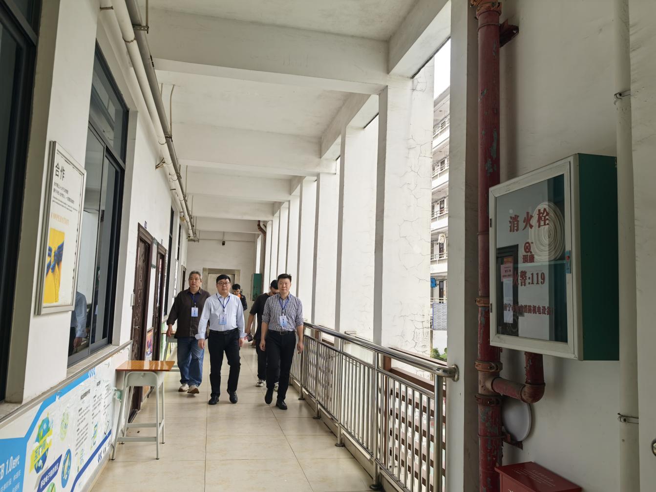 财经商贸系副主任杜国宁（右一）陪同柳州市医学会常务副会长、秘书长、柳州市医药学会科技发展中心（柳州市医学考试中心）负责人伍传仁（中）巡视考场